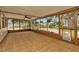 Enclosed sunroom with tiled flooring and large windows showcasing the outdoor view at 5905 Caroline Dr, Wesley Chapel, FL 33545