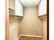 Bright walk-in closet featuring white cabinets, shelving, and hanging racks for optimal storage at 5905 Caroline Dr, Wesley Chapel, FL 33545