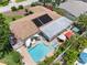 Aerial perspective featuring a pool, a hot tub, lounge furniture, and solar panels at 8300 37Th N Ave, St Petersburg, FL 33710
