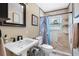 Bathroom featuring a tiled walk-in shower, a classic pedestal sink, and neutral paint at 8300 37Th N Ave, St Petersburg, FL 33710