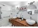 Bathroom featuring double vessel sinks on wood vanity, and a shower with glass door at 8300 37Th N Ave, St Petersburg, FL 33710