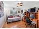 Cozy bedroom featuring hardwood floors, a ceiling fan, a comfortable bed, and a well-lit desk area at 8300 37Th N Ave, St Petersburg, FL 33710