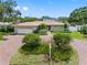 Charming home with lush front yard landscaping, brick driveway, and a two-car garage at 8300 37Th N Ave, St Petersburg, FL 33710