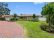Charming one-story home featuring a brick driveway, well-manicured lawn, and lush landscaping at 8300 37Th N Ave, St Petersburg, FL 33710
