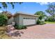 Detached garage with a brick driveway, mature landscaping, and ample parking space at 8300 37Th N Ave, St Petersburg, FL 33710