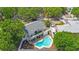 Aerial view of home showing backyard pool, deck, fenced yard, mature trees, and neighborhood setting at 921 Lynnlea Ln, Tarpon Springs, FL 34689