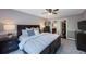 Neutral bedroom with a ceiling fan, carpeted floors, and access to a walk-in closet and the main bathroom at 921 Lynnlea Ln, Tarpon Springs, FL 34689