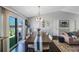 Bright dining area with a chandelier, dark hardwood floors, a view to the back patio, and access to the living room at 921 Lynnlea Ln, Tarpon Springs, FL 34689