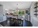 Open dining area featuring a modern chandelier, hardwood floors, and views of the kitchen and back patio at 921 Lynnlea Ln, Tarpon Springs, FL 34689