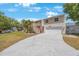 This home has a 2-car garage and ample driveway space with a covered outdoor stairway to the front door at 921 Lynnlea Ln, Tarpon Springs, FL 34689