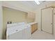 Bright laundry room with white cabinets, sink, and modern appliances at 9460 Bearfoot Trl, Weeki Wachee, FL 34613