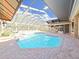 Relaxing enclosed pool area with screened ceiling and brick paved deck at 9460 Bearfoot Trl, Weeki Wachee, FL 34613