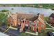 Scenic aerial view of townhouses with a serene lake backdrop, surrounded by lush greenery and colorful buildings at 9740 Lake Chase Island Way # 9740, Tampa, FL 33626