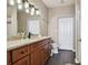 Bathroom boasts a wood vanity, granite countertops, and ample lighting at 9740 Lake Chase Island Way # 9740, Tampa, FL 33626