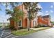 Exterior shot of a charming townhouse with a manicured lawn, mature trees, and a glimpse of a serene lake at 9740 Lake Chase Island Way # 9740, Tampa, FL 33626