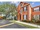 Inviting townhouse with a manicured front lawn, mature trees, and a well-maintained exterior at 9740 Lake Chase Island Way # 9740, Tampa, FL 33626
