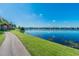 Picturesque lake view showcasing community residences and a tranquil walking trail at 9740 Lake Chase Island Way # 9740, Tampa, FL 33626