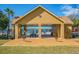 Community pool area featuring an open shelter with picnic tables and barbecue grills, overlooking a serene lake at 9740 Lake Chase Island Way # 9740, Tampa, FL 33626
