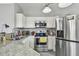 Well-lit kitchen featuring stainless steel appliances, white cabinetry, and stylish countertops at 10442 Villa View Cir, Tampa, FL 33647
