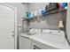 Functional laundry room with modern washer and dryer, plus shelving for storage at 10442 Villa View Cir, Tampa, FL 33647