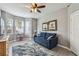Cozy living room with a plush blue sofa, ceiling fan, bay window, and stylish area rug at 10442 Villa View Cir, Tampa, FL 33647