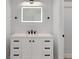 Well-lit bathroom featuring a modern vanity with LED mirror, light countertops, and cabinet storage at 116 Solana St, North Port, FL 34287