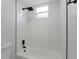 Clean bathroom featuring a shower with white tile, black fixtures, and a small window at 116 Solana St, North Port, FL 34287