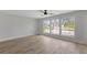 Brightly lit bedroom with wood floors, large window, and neutral paint at 116 Solana St, North Port, FL 34287