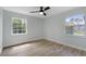 Light and airy bedroom with wood-look floors, two windows and ceiling fan at 116 Solana St, North Port, FL 34287