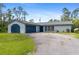 Inviting single-story home with a driveway and a blue accent garage, blending functionality at 116 Solana St, North Port, FL 34287