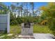 Outdoor stone grill and patio in a backyard surrounded by lush foliage and trees at 116 Solana St, North Port, FL 34287