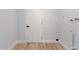 Bright laundry area featuring wood-look flooring, white walls, and utility connections at 116 Solana St, North Port, FL 34287