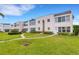 Charming condo complex with manicured lawns and mature landscaping under a beautiful blue sky at 117 Fernwood Cir # 117, Seminole, FL 33777