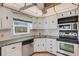 Bright kitchen featuring updated appliances, white cabinetry, and a sunny window view at 117 Fernwood Cir # 117, Seminole, FL 33777