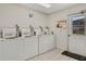 Clean laundry room equipped with multiple washing machines, tile flooring and a door to the outside at 117 Fernwood Cir # 117, Seminole, FL 33777