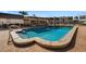 Well-maintained community pool with a brick patio, covered seating, and lush landscaping at 117 Fernwood Cir # 117, Seminole, FL 33777