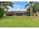 Well-maintained backyard with a screened lanai, green grass, and a view of the home's exterior at 12304 Freesia Ct, Riverview, FL 33569