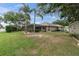 Spacious backyard with a screened lanai, lush lawn, and mature trees at 12304 Freesia Ct, Riverview, FL 33569