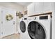 Bright laundry room with modern washer and dryer, cabinetry, and white door at 12304 Freesia Ct, Riverview, FL 33569