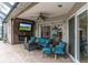 Inviting outdoor patio with a fireplace, TV, comfortable seating, and access to a screened-in lanai at 12304 Freesia Ct, Riverview, FL 33569