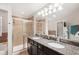 Elegant bathroom with double sinks, granite countertops, and a glass-enclosed shower at 12402 Fairlawn Dr, Riverview, FL 33579