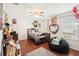 Comfortable bedroom featuring wood floors, a ceiling fan, and a charming heart-shaped mirror at 12402 Fairlawn Dr, Riverview, FL 33579