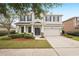 Charming two-story home with a well-manicured lawn, mature tree, and a two-car garage and inviting entrance at 12402 Fairlawn Dr, Riverview, FL 33579