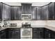 Updated kitchen with black cabinetry, stainless steel appliances, and granite countertops at 12402 Fairlawn Dr, Riverview, FL 33579