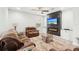 Cozy living room with a fireplace, TV, decorative wall paneling, and plush seating for comfortable relaxation at 12402 Fairlawn Dr, Riverview, FL 33579