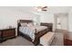 Spacious main bedroom features a wooden bed frame, ceiling fan, and complementary dark wood furniture at 12402 Fairlawn Dr, Riverview, FL 33579