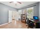 Well-lit home office space featuring a desk, bookshelf, neutral walls, and ample natural light from the windows at 12402 Fairlawn Dr, Riverview, FL 33579