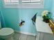 Quirky bathroom with toilet and whimsical decor on light blue walls at 1345 S Evergreen Ave, Clearwater, FL 33756