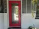 Close-up of a stylish front door with a vibrant color, surrounded by unique decorations and a sleek design at 1345 S Evergreen Ave, Clearwater, FL 33756