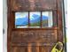 Charming, rustic front door detail with mountain scene displayed in the window pane at 1345 S Evergreen Ave, Clearwater, FL 33756
